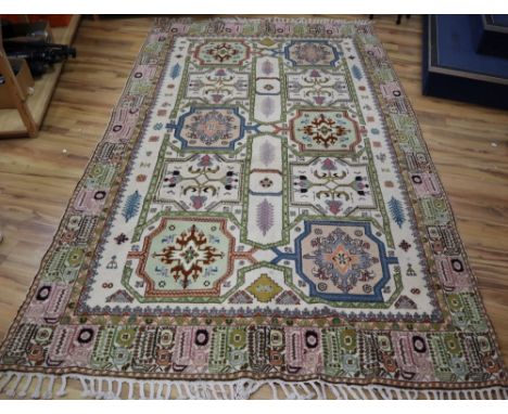 A Caucasian design ivory ground rug, 320 x 195cmCONDITION: One cigar burn and one small patch of lost fabric, spot stained an