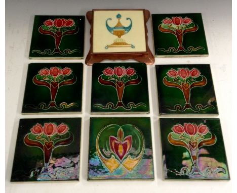 A set of eight Art Nouveau Majolica tiles, each tube lined with stylised flowerheads and sinuous lines, 15cm wide, impressed 