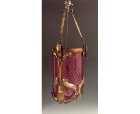 An Art Nouveau copper and cranberry ceiling light, the framed with sinuous scrolls, spirally turned cranberry glass sleeve, 3