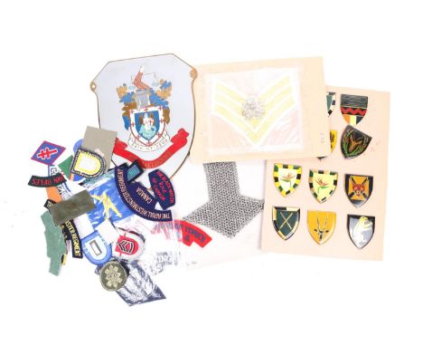 A box of mixed military insignia including Indian titles and formation badges, Canadian post WWII titles, modern US insignia,