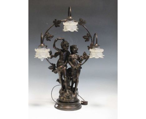 A modern spelter figural table lamp, depicting two children clad in robes and roses in front of a foliate halo, with floral g