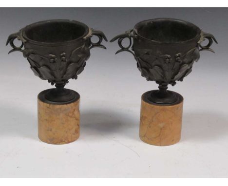 A pair of late 19th century bronze vessels with yellow marble bases, together with a black leather blackjack jug