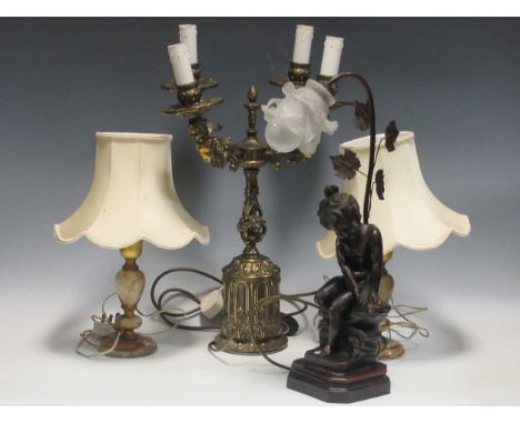 A modern gilt metal four branch table light, two other onyx-based lamps and a modern figural lamp