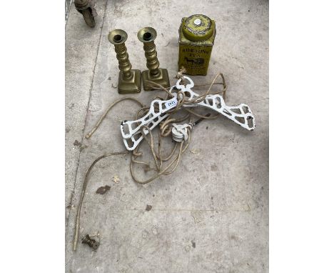 A CAST IRON SUSPENDED CLOTHES AIRER, TWO BRASS CANDLESTICK AND A RINGTONS TEA CADDY 
