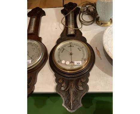 AN ORNATE WOODEN CASED BAROMETER 