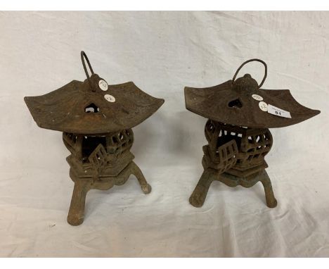A PAIR OF CAST PAGODA STYLE TEA LIGHT CANDLE HOLDERS 