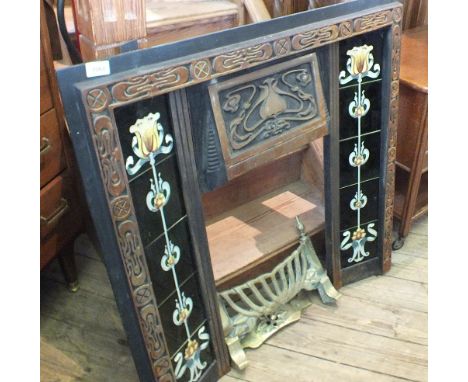 An Art Nouveau style iron fire surround with floral tiles and brass fire front