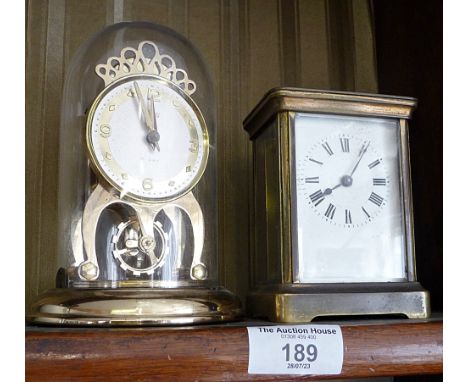Brass carriage clock and a Shatz 8 day clock under a dome