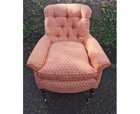 A Victorian upholstered Howard style armchair, with button back, deep seat, supported on turned legs with castors, 88 cm high