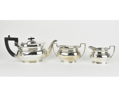 A George V silver three piece tea set by A.W.J.H, Sheffield 1921, comprising a teapot with ebony handle and finial, a twin ha