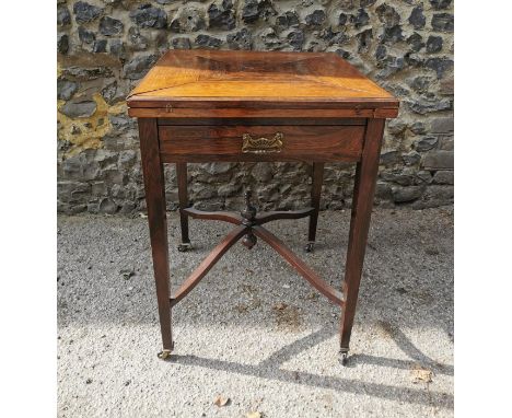 An Edwardian rosewood envelope card table, with frieze drawer, the top opening to a green baize square surface, supported on 