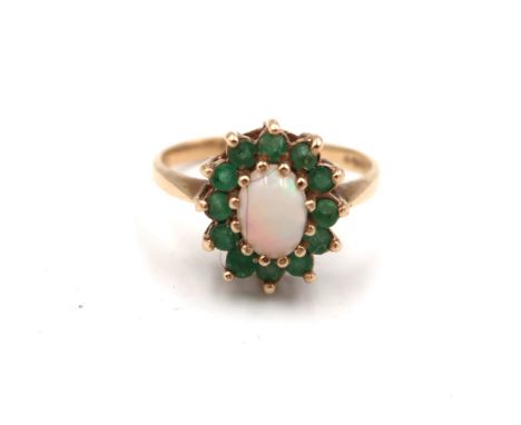 A 9ct yellow gold dress cluster ring with green paste set around a central oval opal - ring size N - approx weight 2.7 grams 