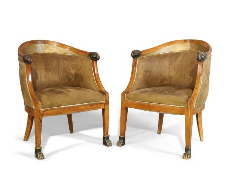 A pair of brass-mounted Empire mahogany tub chairs, first quarter 19th century, with lion head arms, on tapering legs to paw 