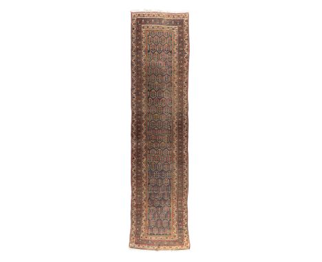 A Kurdish runner, first quarter 20th century, the central field with geometric motifs, on a blue ground, contained by geometr