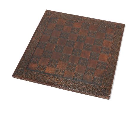 A late Victorian carved oak chessboard, late 19th century, the border and black squares carved with 'parchemin' style ornamen