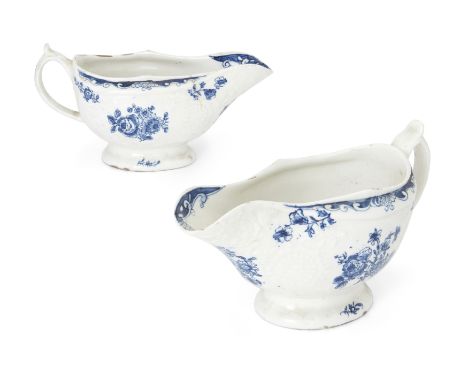 A pair of Lowestoft blue and white porcelain sauce boats, c.1770, blue crescent marks, each moulded with flowers and scrolls 