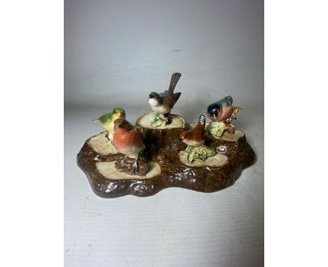 A SET OF FIVE BESWICK BIRDS ON A TREE TRUNK STAND TO INCLUDE A WHITETHROAT, ROBIN, BULLFINCH, WREN AND A GREENFINCH