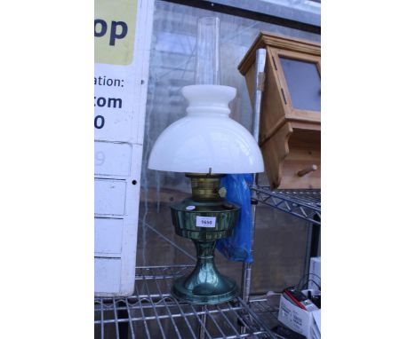 A METALIC GREEN METAL OIL LAMP COMPLETE WITH GLASS SHADE AND FUNNEL