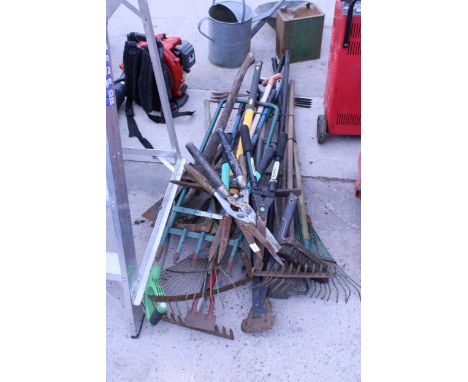 A LARGE ASSORTMENT OF GARDEN TOOLS TO INCLUDE RAKES, SHEARS AND SPADES ETC