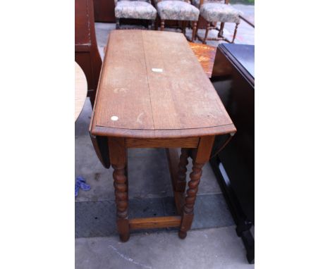 A LIGHT OAK GATE-LEG TABLE ON BARLEY-TWIST LEGS