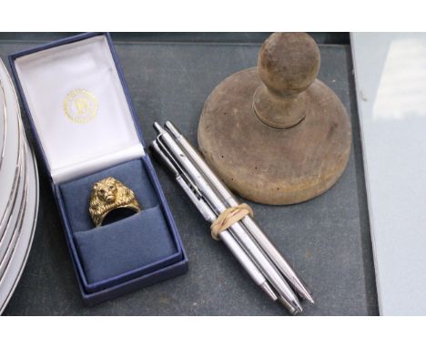 A MIXED LOT TO INCLUDE A LION'S HEAD RING WITH THE INSCRIPTION 'HEART OF A LION', A QUANTITY OF PENS PLUS A BUTTER PAT