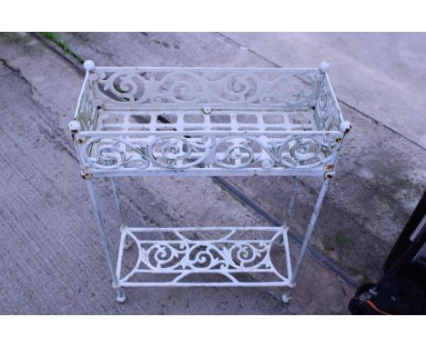 A DECORATIVE METAL PLANT STAND WITH LOWER SHELF