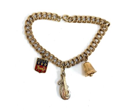 A gold curb link charm bracelet, unmarked but tests as 9ct, with a later gold plated bolt clasp, with three charms including 