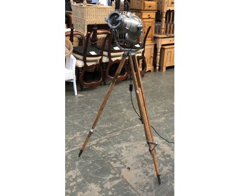 A vintage aluminium theatre lamp, stamped 'Strand Electric', on adjustable wooden tripod base 