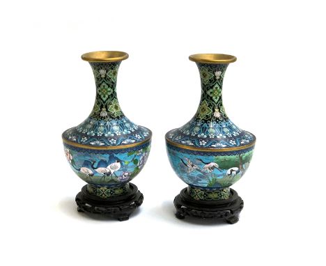 A pair of Chinese cloisonne enamel vases, depicting cranes and flowers, 25cm high, each on a carved hardwood base 