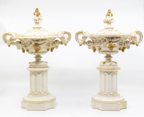 A pair of Royal Worcester lidded urns, on pillars, with fruit and leaf design