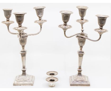 A pair of Edwardian Neo-Classical style silver candelabra, urn shaped sconces above tapering fluted stems on raised square fe