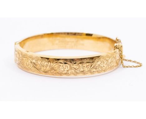 A 9ct gold hinged bangle, hollow form with engraved foliate, width approx 10mm, internal diameter approx 60mm, presentation i