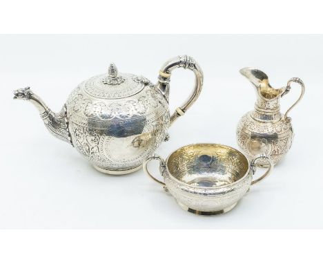 A matched Victorian three piece tea service comprising teapot, sugar bowl and milk jug, each body profusely chased with shape