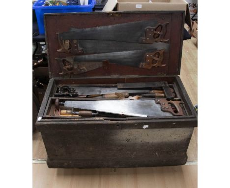Tool trunk on castors containing all wooden handled tools including a plane, chisels, drill, set squares and early to mid 20t