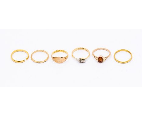 Six gold rings, including two 22ct gold bands, (one cut through) weight approx 4gms, an 18ct three stone diamond ring, size M