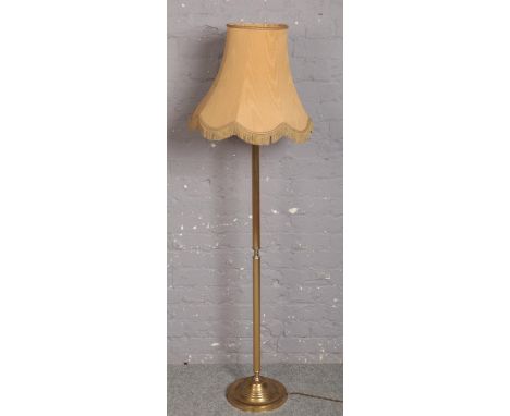 A brass standard lamp with circular base  
