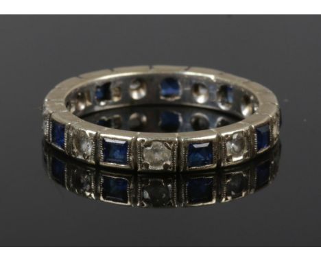 A 9ct gold eternity ring set with alternating blue and white paste stones, size K 1/2.  