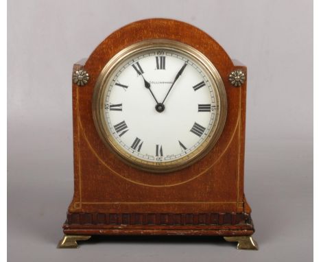 An Edwardian mahogany cased mantel clock with enamel dial signed Collingwood and raised on brass bracket feet. Housing a Swis