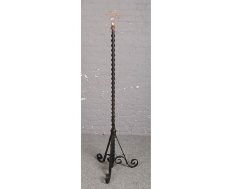 A wrought iron standard lamp, with scrolling supports.  