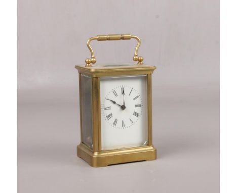 A brass cased carriage clock. With Swiss 8 day movement having platform escapement, 14cm.  Running. Front glass cracked acros
