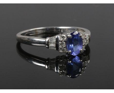 An Art Deco style 18ct white gold tanzanite and diamond ring. With an ovoid centre stone and having baguette and brilliant cu