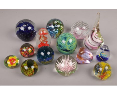 A collection of glass paperweights to include art glass examples etc.  