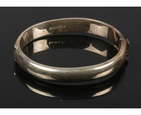 A silver bangle with engraving detailing.  