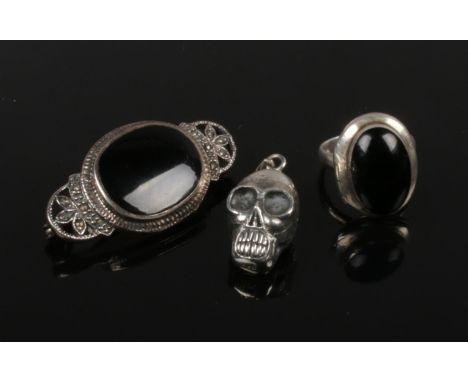 A jet and silver locket top ring, silver, jet and marcasite brooch and a silver skull pendant.  