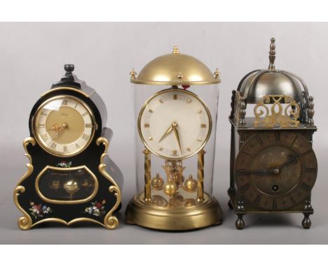 A German brass torsion clock in glass case, A Kern tosion clock in ebonized French style case and a brass cased lantern clock
