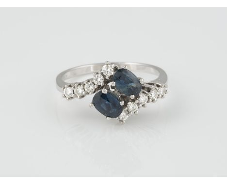 RING Weißgold. Ringmaß ca. 60, Ges.-Gew. ca. 3,8 g. Geprüft 14 K. Zwei oval facettierte Saphire zusammen ca. 0,9 ct., 10 Bril
