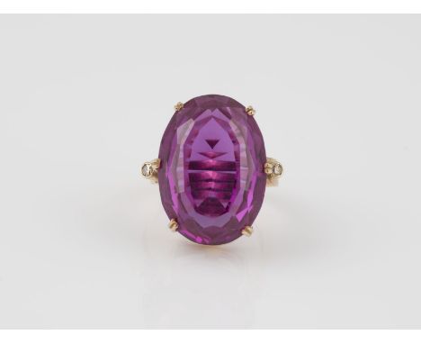 RING Gelbgold. Ringmaß ca. 53,5, Ges.-Gew. ca. 10,3 g. Geprüft 14 K. Ein oval facettierter, lila-blauer Farbstein, ca. 21,8 x
