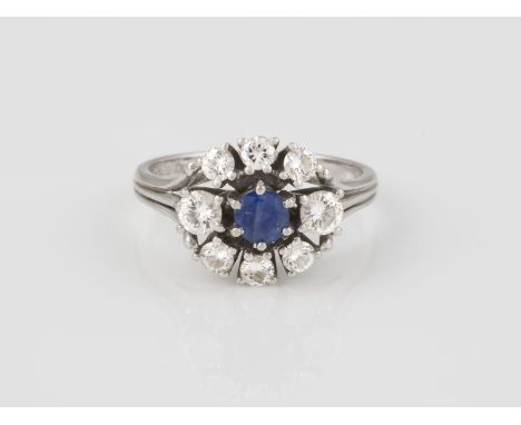 RING Weißgold. Ringmaß ca. 56, Ges.-Gew. ca. 4,7 g. Gest. 750. Ein rund facettierter Saphir, ca. 0,45 ct., acht Brillanten, z