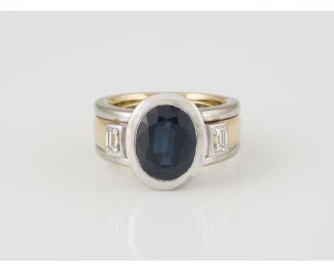 RING Gelbgold, Weißgold. Ringmaß ca. 54, Ges.-Gew. ca. 21,3 g. Geprüft 18 K. Ein oval facettierter Saphir, ca. 4,30 ct., zwei