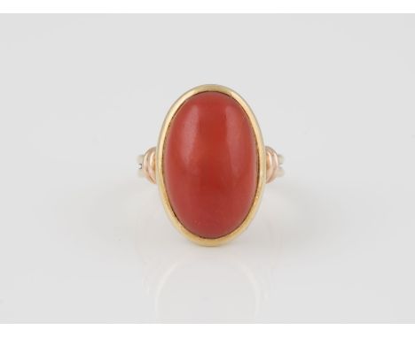 RING Gelbgold, Rotgold. Ringmaß ca. 57, Ges.-Gew. ca. 9,4 g. Gest. 585. Ein ovaler Korall-Cabochon, ca. 20,4 x 13 x 7,4 mm. V